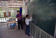 Un enseignant interroge un élève au tableau dans une école primaire de la province de Kampong Chhnang au Cambodge, le 27 juin 2018