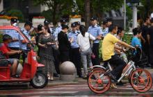 La police surveillant l'identification des passants près du siège de l'autorité chinoise de régulation bancaire (CBRC) à Pékin le 6 août 2018