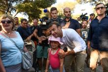 Emmanuel Macron pose pour les caméras lors d'un bain de foule le 7 août 2018 à Bormes-les-Mimosas, non loin du Fort de Bregancon, résidence d'été des présidents français