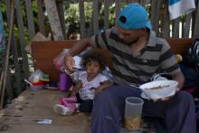 Un Vénézuélien et sa fille déjeunent dans leur abri de fortune à Boa Vista au Brésil, le 23 août 2018