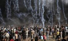 Une photo prise le 17 août 2018 montre des gaz lacrymogènes tirés par les soldats israéliens sur des Palestiniens protestant dans la bande de Gaza près de la barrière de sécurité israélienne
