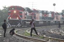 Des migrants d'Amérique centrale marchent le long des voies ferrées dans l'attente d'un train à destination des Etats-Unis, le 10 août 2018 à Guadalajara, au Mexique