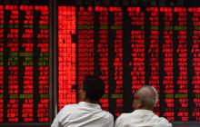 Des investisseurs chinois devant un tableau d'indices boursiers, le 15 juin 2017 à Pékin