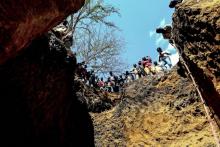 Des mineurs illégaux au bord d'un gouffre où ils espèrent trouver des pierres précieuses, près du village de Nthoro, le 3 août 2018 au Mozambique