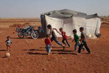 Des enfants syriens jouent à la balle devant une tente dans un camp de déplacés près du village de Surman dans la province d'Idleb en Syrie, le 5 septembre 2018
