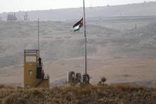 Une photo prise du côté israélien de la barrière à Baqoura (appelé Naharayim du côté israélien) montre le drapeau jordanien sur un poste militaire, le 22 octobre 2018