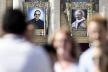 Portraits de l'archevêque salvadorien Oscar Romero (g) et du pape Paul VI (d) sur la façade de la Basilique Saint-Pierre, au Vatican, le 13 octobre 2018