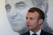 Emmanuel Macron devant le portrait de Charles Aznavour à Erevan lors du sommet de la francophonie, le 11 octobre 2018