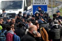 Des migrants face à un blocus de la police, sur la frontière avec la Croatie, à Velika Kladusa, en Bosnie-Herzégovine, le 24 octobre 2018