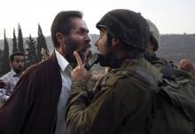 Un palestinien et un soldat israélien se dispute après la décision des autorités israéliennes de fermer une école palestinienne dans la ville d'as-Sawiyah, au sud de Naplouse, le 15 octobre 2018
