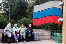 Des femmes âgées assises sur un banc près du drapeau russe, le 15 septembre 2018, dans la banlieue de Saint-Pétersbourg