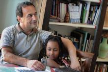 Photo d'archives du maire de Riace, Domenico Lucano, dans son bureau avec une fillette venue d'Ethiopie, le 22 juin 2011