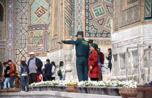 Des membres de la toute récente "police des touristes" en Ouzbékistan aident une voyageuse à Samarcande, le 28 mars 2018