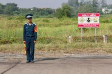 Un soldat vietnamien près d'un panneau avertissant de la dangerosité d'un ancien site de stockage de l'Agent orange, le 17 octobre 2018 sur la base aérienne de Bien Hoa, près de Ho-Chi Minh-Ville