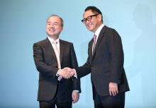 Le patron du groupe SoftBank Masayoshi Son (g) et celui de Toyota Motor, Akio Toyoda, échangent une poignée de mains à Tokyo, le 4 octobre 2018