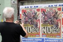 Un passant photographie une affiche contre le sommet du G20, le 27 novembre 2018 à Buenos Aires, en Argentine