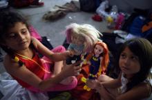 Des enfants centraméricains en route vers les Etats-Unis jouent à la poupée dans un campement de fortune à Irapuato, dans l'ouest du Mexique, le 11 novembre 2018