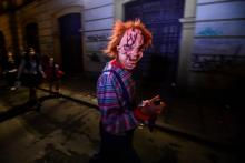 Une personne masquée marche dans les rues de Bogota le 31 octobre 2018 lors de la fête de Halloween