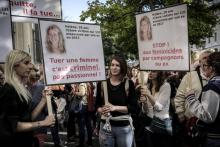 Des pancartes à l'effigie d'une jeune femme tuée par son ex-compagnon lors d'un rassemblement le 6 octobre 2018, à Paris, contre les violences faites aux femmes