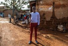 Le jeune entrepreneur ougandais Moris Atwine pose avec son smartphone dans la banlieue de Kampala, le 12 novembre 2018. Il a contribué à développer une technologie mobile permettant de dépister le pal
