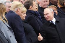 Le président russe Vladimir Poutine s'entretient avec son homologue américain Donal Trump, devant la chancelière allemande Angela Merkel, le 11 novembre 2018 à Paris.