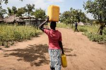Une réfugiée sud-soudanaise transporte de l'eau dans un camp de réfugiés en Ouganda, le 26 novembre 2017