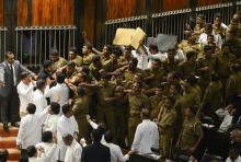 La police a dû escorter le président du parlement du Sri Lanka Karu Jayasuriya à l'intérieur de l'assemblée face aux députés opposés qui lui jetaient des objets à la figure, le 16 novembre 2018