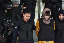 La Vietnamienne Thi Huong (2e d) et l’Indonésienne Siti Aisyah (2e g arrière-plan), escortées par des policiers à l'issue de leur comparution devant la Haute cour de Shah Alam, le 27 juin 2018 à la pé