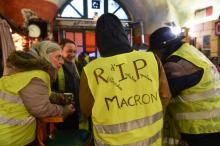 Une pancarte réclamant l'instauration d'un référendum d'initiative citoyenne (RIC) est brandie lors d'une manifestation de "gilets jaunes" à Paris, le 15 décembre 2018