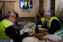 Des "gilets jaunes" regardent l'intervention d'Emmanuel Macron à la télévision dans un restaurant à Fay-au-Loges, le 10 décembre 2018