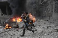 Un secouriste syrien porte un enfant blessé après un bombardement du régime syrien et de son allié russe sur Hammouriyé, dans la Ghouta orientale (Syrie), le 6 janvier 2018