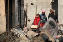 Des civils inspectent les décombres à leur retour dans la ville de Hajine, un ancien fief du groupe Etat islamique (EI) en Syrie, le 27 janvier 2019