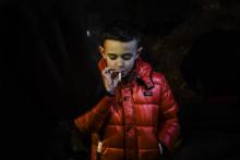 Un jeune garçon fume une cigarette au cours de la célébration de l'Epiphanie dans le village de Vale de Salgueiro, le 5 janvier 2019 au Portugal