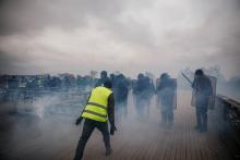 Un "gilet jaune" face à des policiers anti-émeutes, sur un pont parisien le 5 janvier 2019