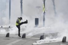 Un manifestant "gilet jaune" renvoie un projectile contenant du gaz lacrymogène lors d'une manifestation anti-gouvernementale à Nantes (ouest) le 26 janvier 2019.