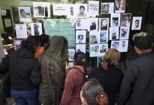 Des personnes cherchent les noms de leurs proches sur la liste des disparus dans l'explosion d'un oléoduc perforé par des voleurs de carburants, à Tlahuelilpan, dans le centre du Mexique, le 20 janvie