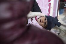 Un enfant porté par une femme attend dans une clinique de fortune dans le camp de déplacés d'Al-Hol, dans le nord-est de la Syrie, le 7 février 2019
