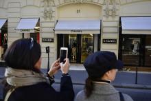 Une femme photographie la façade de la maison de couture Chanel à Paris le 19 février 2019