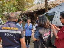 Photographie prise et diffusée le 15 février 2019 par la police de l'immigration thaïlandaise montrant Kaeomanee Arjaw (C) saluant des policiers à son retour chez elle à Chiang Rai après une longue ma