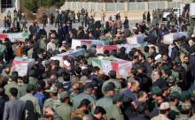 Des Iraniens portent les cercueils des victimes d'un attentat suicide contre un bus des Gardiens de la Révolution à leur arrivée à l'aéroport d'Isfahan, le 14 février 2019