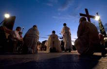 Des prêtres espagnols à genoux pour prier à Madrid le 30 juillet 2011