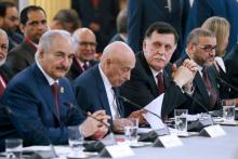 Le maréchal Khalifa Haftar, l'homme fort de l'est libyen (G), et le chef du gouvernement d'union basé à Tripoli (ouest) Fayyez al-Sarraj (au milieu), le 29 mai 2018 lors d'une conférence sur la Libye 