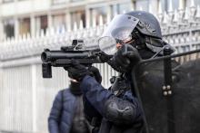 Un policier pointe un lanceur de balles de défense (LBD) vers des manifestants lors d'un défilé de "gilets jaunes" à Paris, le 9 février 2019