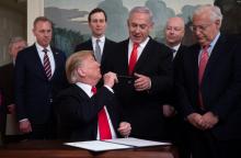 Donald Trump tend son stylo au Premier ministre israélien Benjamin Netanyahu après avoir signé le décret reconnaissant officiellement la souveraineté d'Israël sur le plateau du Golan, le 25 mars 2019 