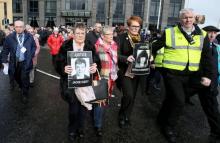 Des membres des familles des victimes du Bloody Sunday défilent le 14 mars 2019 à Derry avec des portraits de leurs proches tués