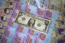 Des billets de dollars et de bolivars pris en photo le 28 janvier 2019 à Caracas