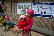 Une femme et son enfant passent devant un monastère transformé en centre d'hébergement dans l'Etat Shan, dans le nord-est de la Birmanie, en proie à un conflit entre factions rebelles