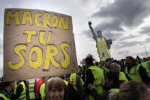 Des "gilets jaunes" à Colmar, le 2 mars 2019, réclament le départ d'Emmanuel Macron, près d'une réplique de la Statue de la Liberté vêtue d'un gilet jaune