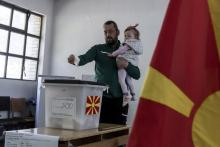 Des partisans de l'Union sociale démocrate de Macédoine, au pouvoir, pendant un meeting électoral à Skopje, devant une affiche de la candidate de l'opposition Gordana Siljanovska, le 14 avril 2019