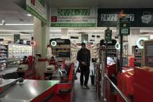 Un client passe à une caisse automatique pour regler ses achats en pleine nuit au supermarché Casino, le 15 mars 2019